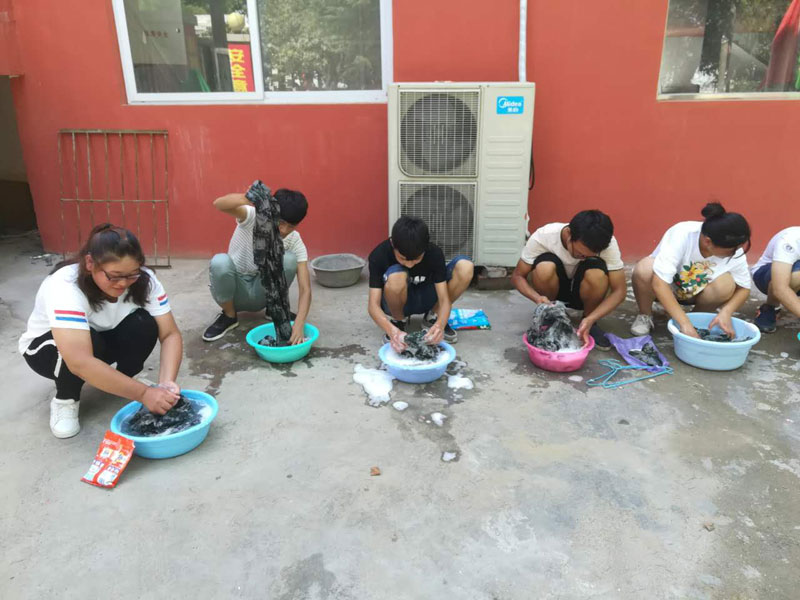 郑州长城科技中等专业学校老师教学生洗衣服