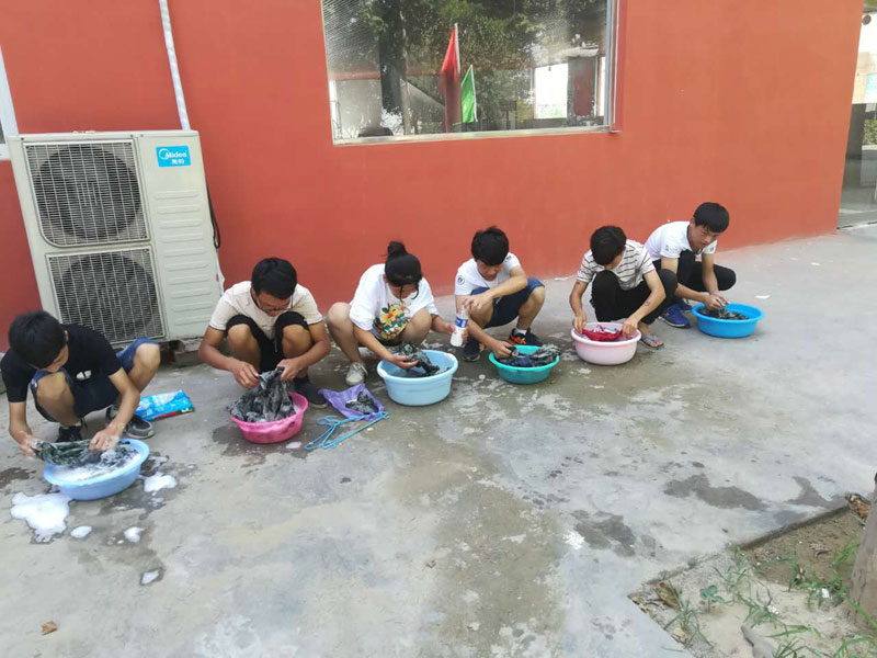 郑州长城科技中等专业学校老师教学生洗衣服